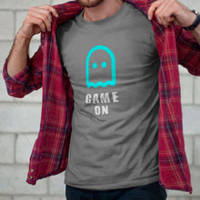 Game-On-Ghost-Grey-T-Shirt-on-Bearded-Man-Putting-on-a-Plaid-Shirt-Over-the-Tshirt-From-ForzaTees